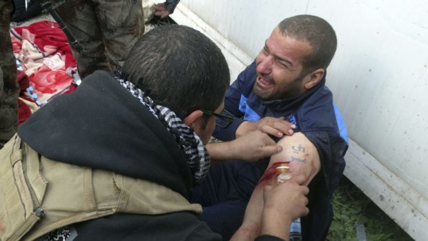 A wounded civilian is treated by a soldier on Thursday as Iraqi security forces help civilians trapped in Ramadi.