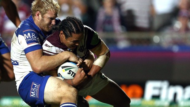 Controversial moment:  Steve Matai of the Sea Eagles scores a try despite the tackle, and protests, of Aiden Tolman.