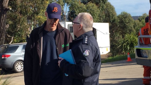 David Curry speaks to a police officer at Aireys Inlet, where his wife Elisa went missing.