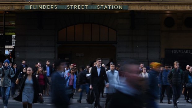 Commuters pour out of Flinders Street Station. 