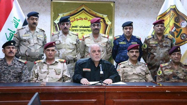 Iraqi Prime Minister Haider al-Abadi (centre, in black) has declared the city of Mosul liberated from Islamic State.