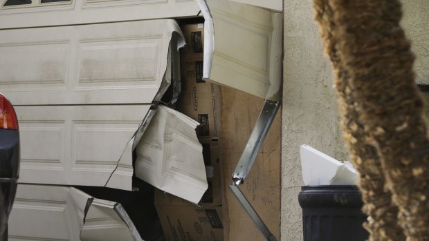 A garage door of Enrique Marquez's home is seen broken after a recent FBI raid.