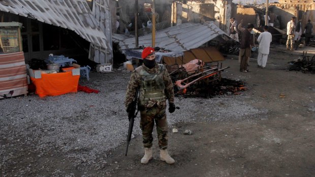 An Afghan soldier stands guard at Kandahar airport after clashes between Taliban fighters.