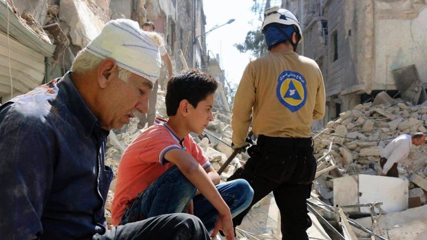 Residents sit among rubble in rebel-held eastern Aleppo, Syria last month.