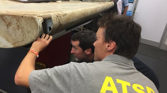 Malaysian and Australian investigators examine the piece of aircraft debris found on Pemba Island off the coast of Tanzania.