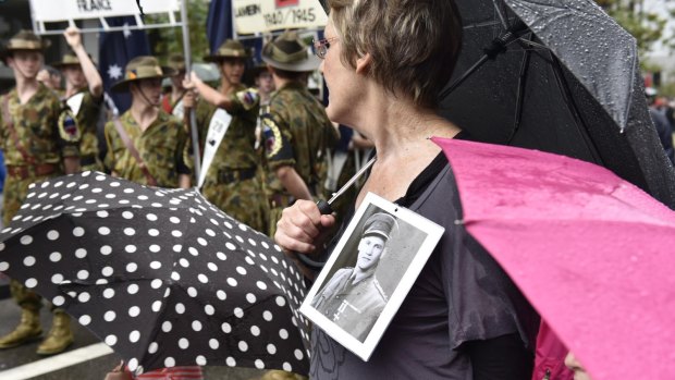 Umbrellas and plastic ponchos were prized items at Perth's Anzac parade. 