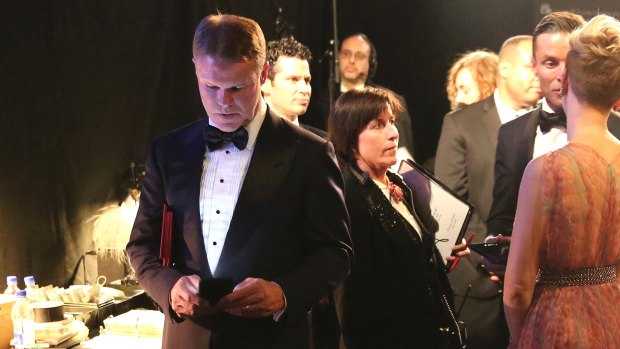 Accountant Brian Cullinan holds red envelopes under his arm while using his cell phone backstage at the Oscars.