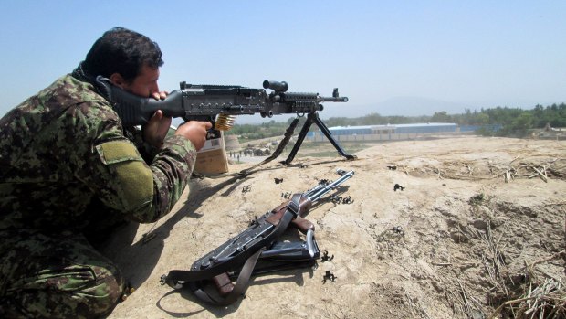 An Afghan soldier aims at Taliban insurgents in Kunduz province on Sunday.
