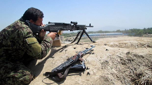 An Afghan soldier aims at Taliban insurgents in Kunduz province on Sunday.