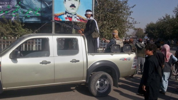 A Taliban fighter stands guard on a vehicle in Kunduz.