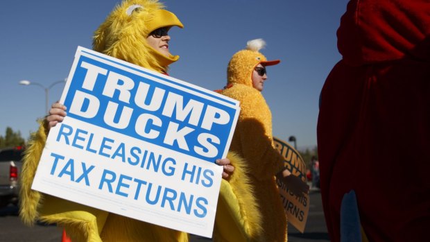 A demonstrator holds a sign while protesting before a campaign event with Donald Trump in Henderson, Nevada, on Wednesday. 