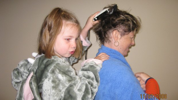Belinda Thomson gets her head shaved with the help of her daughter Emma. 