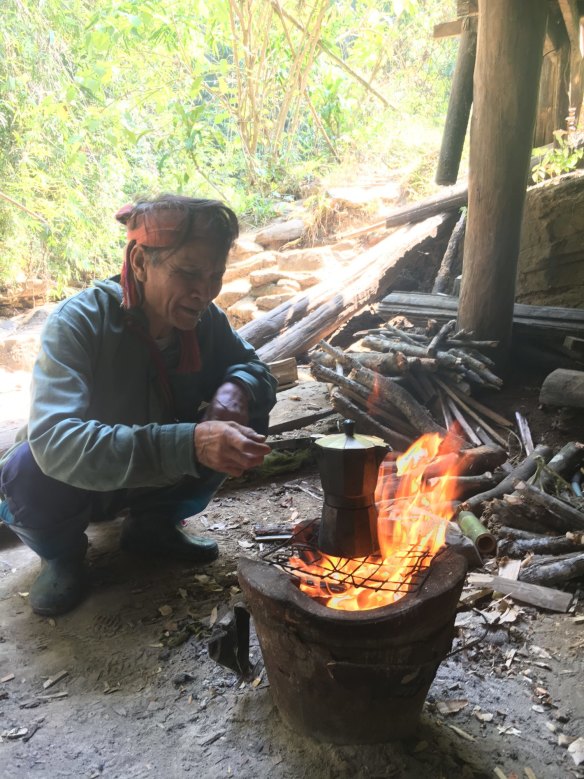A vendor brewing local coffee beans over an open fire in Thailand's north.