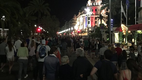 Crowds walk down the Promenade des Anglais moments before a truck fatally hits 84 people.