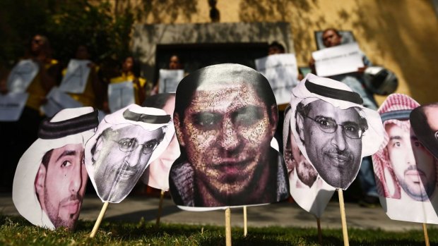 A photo of Saudi blogger Raif Badawi (centre) with photos of other prisoners in Saudi Arabia at a protest in Mexico calling for his release. 