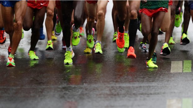 Marathon runners compete on rain-slicked streets at the Rio Olympics.