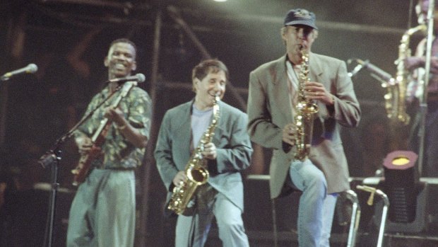 Paul Simon, centre, with lead guitarist Ray Phiri, left, and actor-comedian Chevy Chase on the saxophone, New York, 1991.