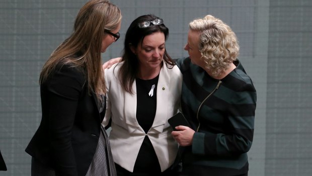 Colleagues comfort Labor MP Emma Husar after she spoke about her experience of living with family violence in House of Representatives last year.