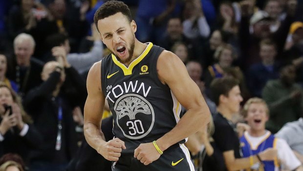 Golden State Warriors guard Stephen Curry reacts after scoring during the first half of the team's NBA basketball game against the Memphis Grizzlies. 