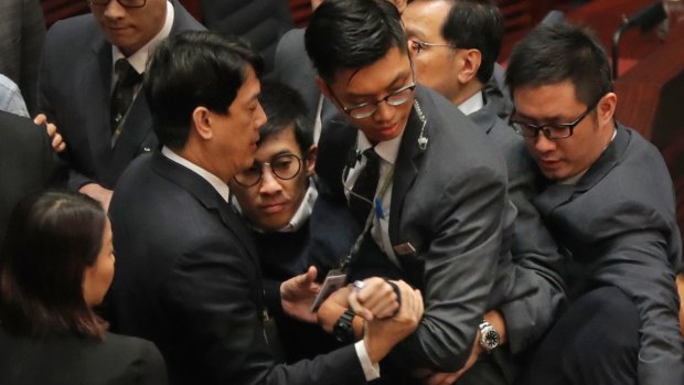 Sixtus Leung, centre, is blocked by security guards as he tries to retake the oath at Hong Kong's Legislative Council earlier this month.