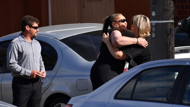 Family and friends embrace, as they arrive at the funeral service for Karen Ristevski in Essendon.
