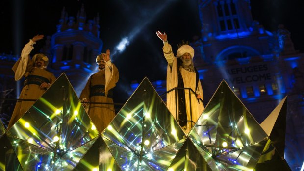 A man dressed as Melchor, right, one of the Three Wise Man waves to the crowd from a float during the Epiphany parade in Madrid.