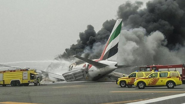 Crews work to extinguish a fire on Emirates flight EK521 after it was involved in an accident.