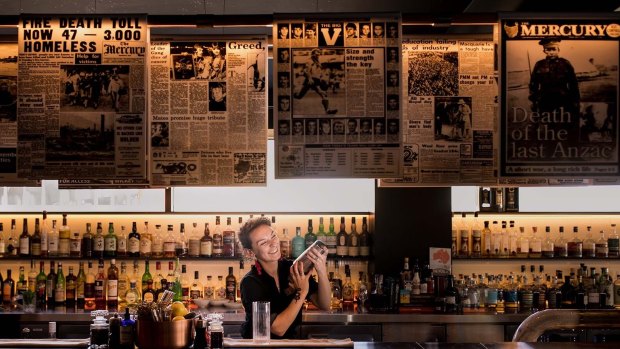 Mixing drinks in front of the front pages at the MACq01 Story Bar