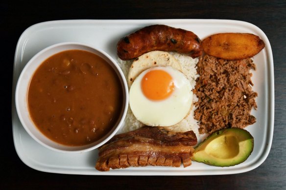 Bandeja paisa platter with braised red beans, chicharron (fried pork belly), minced beef, Colombian chorizo,  plantain, avocado, arepa, fried egg and rice.