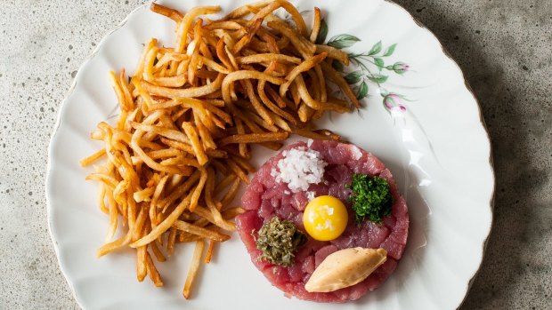 Bar Kismet's famous ahi tuna tartare, loaded with capers, quail egg yolk and spicy mayo and served with a heart-stopping pile of crispy-thin allumette fries. 