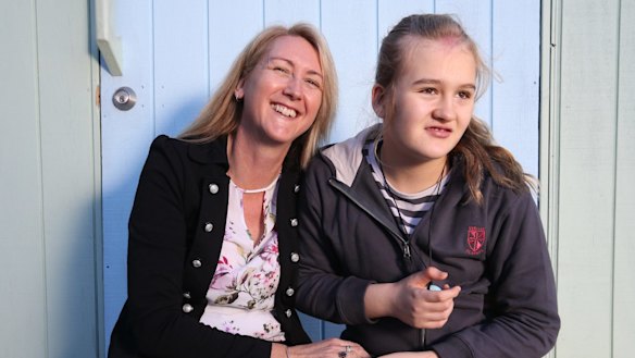 Nichole Brimble (left) communicates with her daughter Abbey, 12, using hundreds of colourful flashcards.