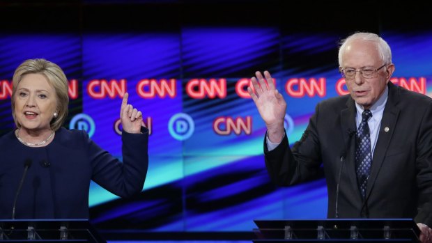 Democratic presidential candidate Hillary Clinton argues a point as Senator Bernie Sanders reacts during a primary debate at the University of Michigan in Flint.