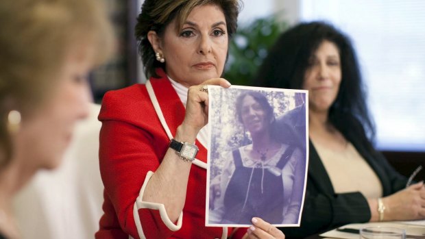 Gloria Allred holds a photo of Margie Shapiro, right, at about the age she says she was assaulted by Bill Cosby, during a press conference in Los Angeles on Friday.