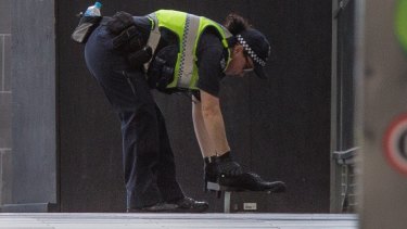 A police officer removes the 'suspicious' shoes.
