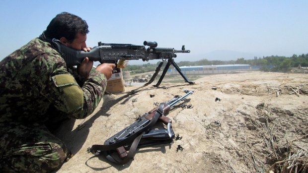 An Afghan security force member aims his weapon during a battle with Taliban insurgents in Kunduz on Sunday.