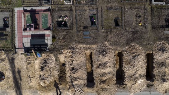 A cemetery worker takes a rest from working on the graves of civilians killed in Bucha during the war with Russia, in the outskirts of Kyiv, Ukraine, Thursday April 14, 2022. (AP Photo/Rodrigo Abd)