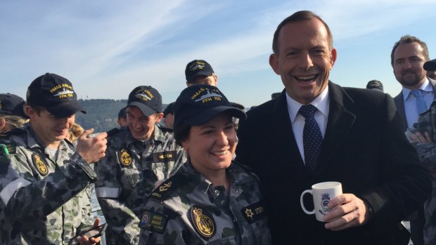 Prime Minister Tony Abbott enjoys a cuppa on the deck of HMAS Anzac.