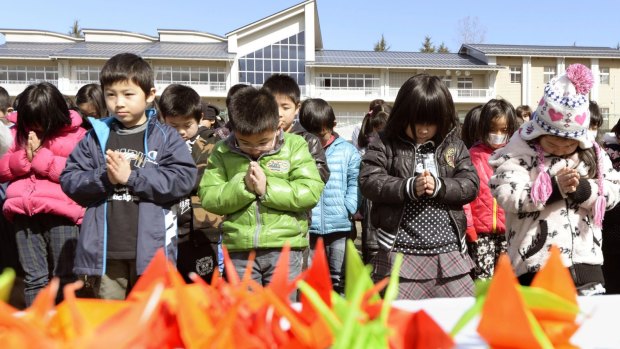 Students of an elementary school pray for victims of the March 11, 2011 earthquake and tsunami in Japan.
