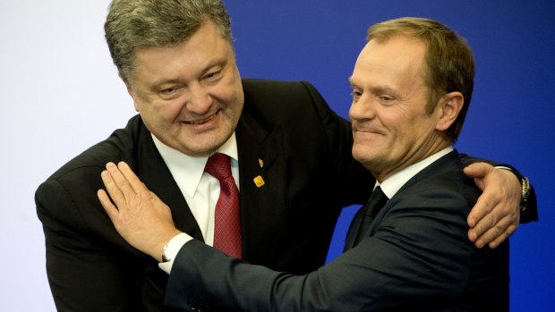 Ukrainian President Petro Poroshenko, left, embraces European Council president Donald Tusk after a joint press conference in Brussels after an accord was signed in Minsk.