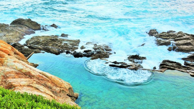 At the bottom of imposing cliffs, Bermagui's Blue Pools is a haven for families on a hot summer's day.