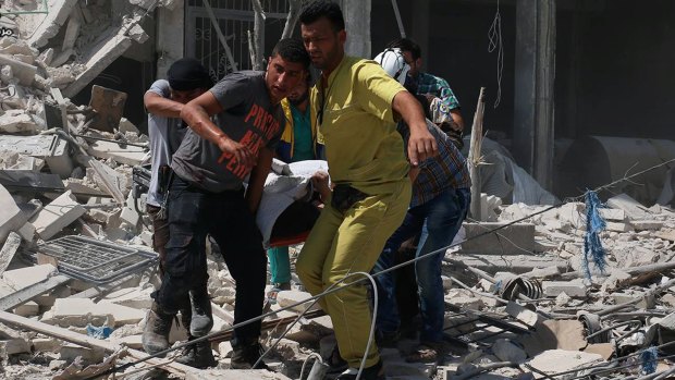 Syrians carry a victim after barrel bombs were dropped on the Bab al-Nairab neighbourhood in Aleppo, Syria, on Saturday.
