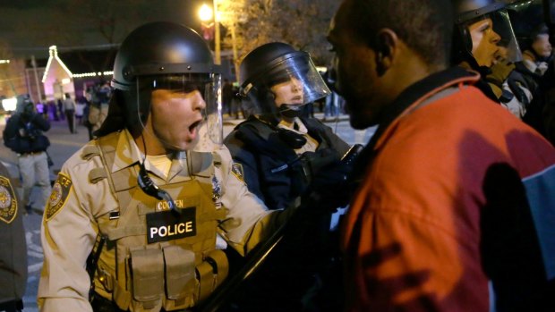 Police confront protesters after the announcement of the grand jury decision not to indict police officer Darren Wilson in the fatal shooting of Michael Brown in November last year. 