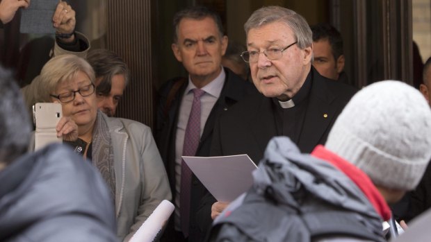 Cardinal George Pell reads a statement to reporters as he leaves the Quirinale hotel after meeting with survivors of sex abuse.