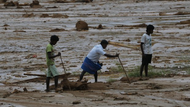 Sri Lankan landslide survivors try to salvage their belongings buried in the mud after a landslide in Elangipitiya village on Wednesday. 