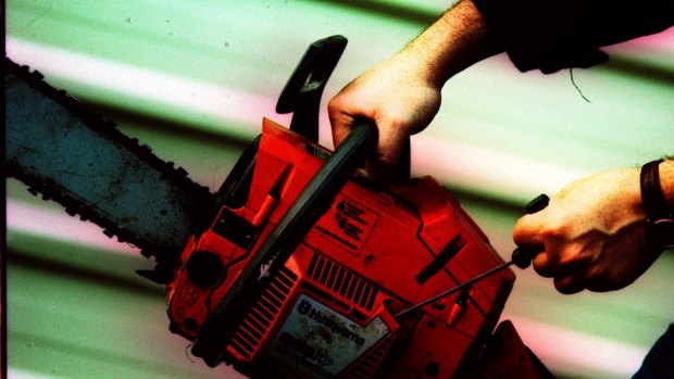 Police allege a man ran at them with a chainsaw on Saturday night.