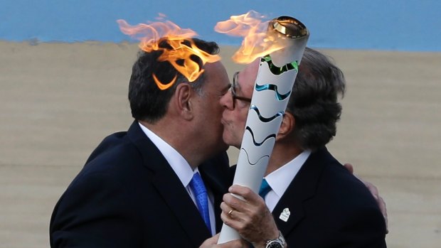 Carlos Nuzman, right, receives the torch Olympic Flame from the head of Greece's Olympic Committee, Spyros Capralos during the handover ceremony at Panathinean stadium in Athens in 2016.