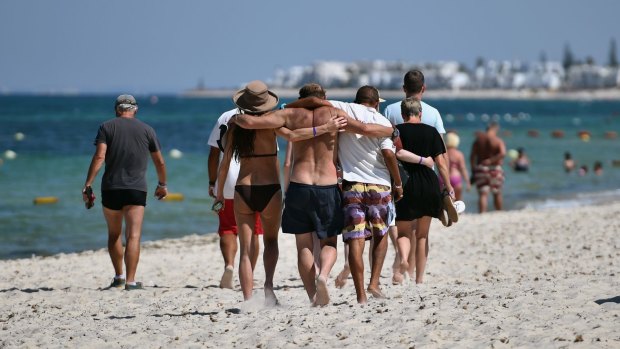 People lock arms after viewing the deadly scene at the beach.