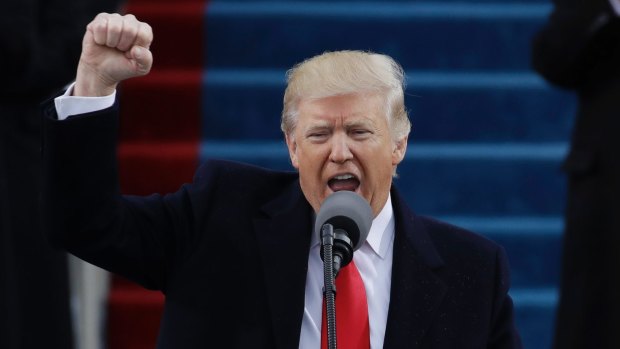 President Donald Trump pumps his fist after delivering his inaugural address.