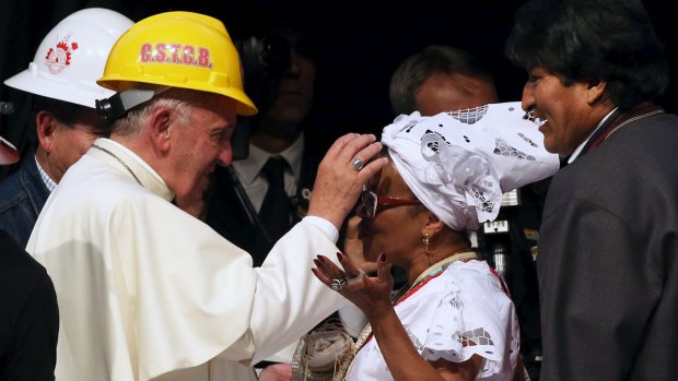 Pope Francis blesses a woman as Bolivian President Evo Morales (R) looks on, during a World Meeting of Popular Movements in Santa Cruz, Bolivia, on July 9. 