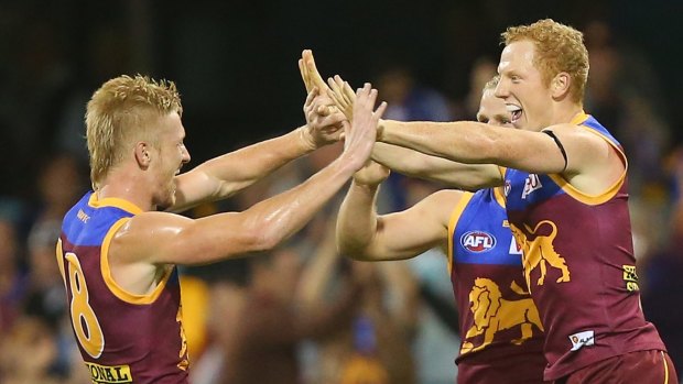 BRISBANE, AUSTRALIA - MAY 17:  Nick Robertson, Daniel Rich and Josh Green of the Lions celebrate a goal during the round seven AFL match between the Brisbane Lions and the Port Adelaide Power at The Gabba on May 17, 2015 in Brisbane, Australia.  (Photo by Chris Hyde/Getty Images)